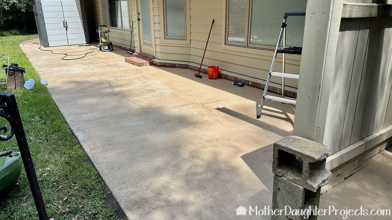 Using a Ryobi electric pressure washer to clean the patio.