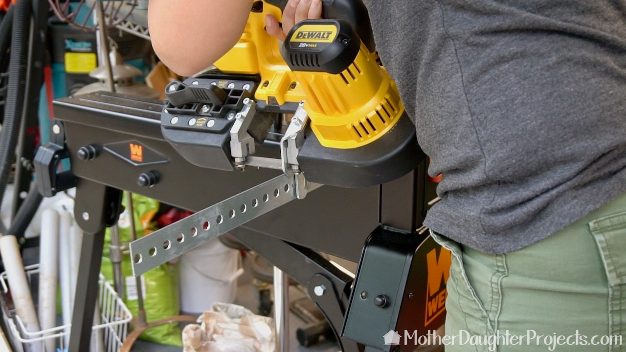 Cutting the slotted metal flat bar with a DeWalt battery powered band saw.
