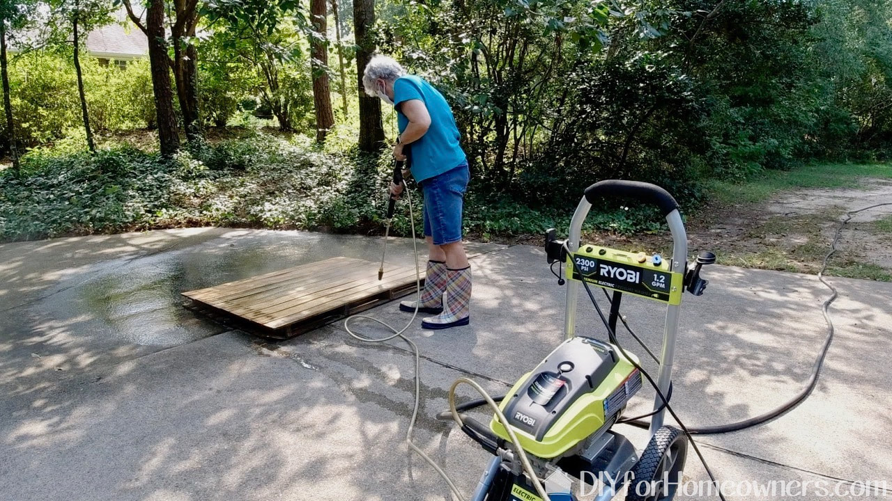 Pressure washing the dirty pallets with a Ryobi pressure washer. 
