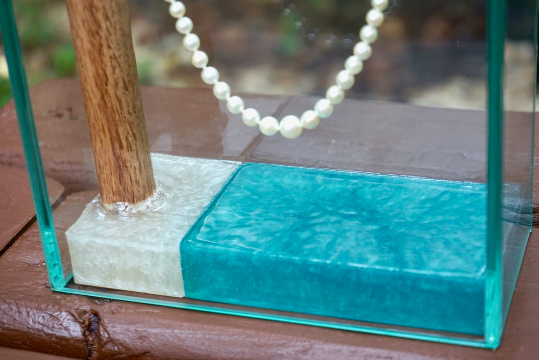Vintage pearl necklace in glass display case with epoxy base.