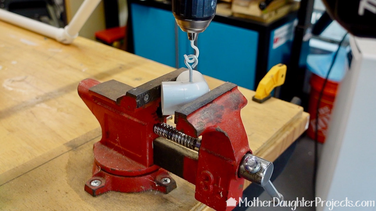 Use a cup hook fitted into a drill to quickly screw in eye hooks.