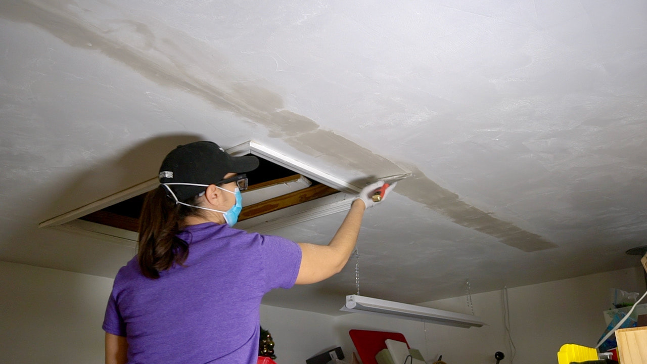 Applying the second coat of mud to the ceiling crack.