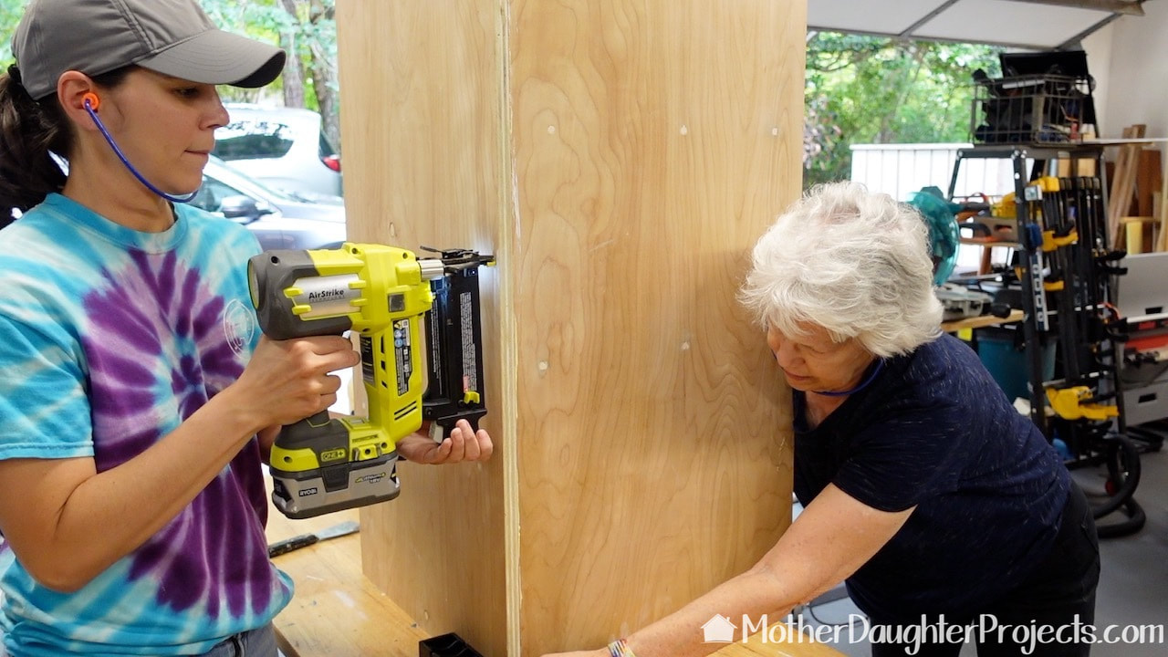 This is going to be a cabinet that fits into a corner. Here we are gluing and brad nailing the corner together.