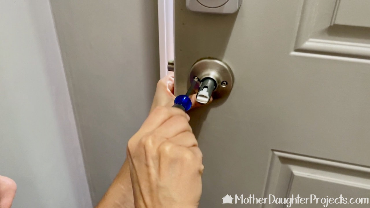 Make sure the base fits through the latch bolt and sits flush to the door before lighting those two screws. 