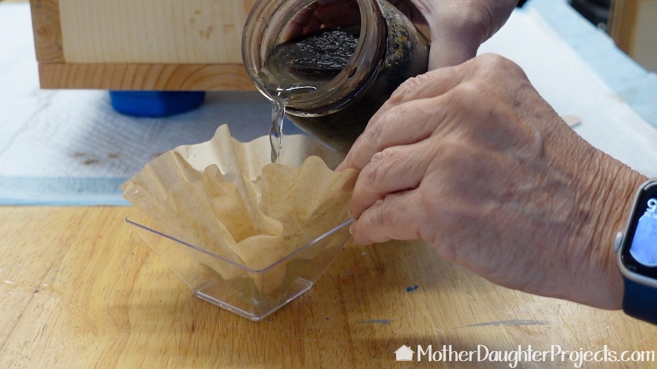 The stain is made by steeping steel wool in vinegar for a few days. Here's I'm straining it through a coffee filter to catch any debris I don't want to transfer to the wood box.