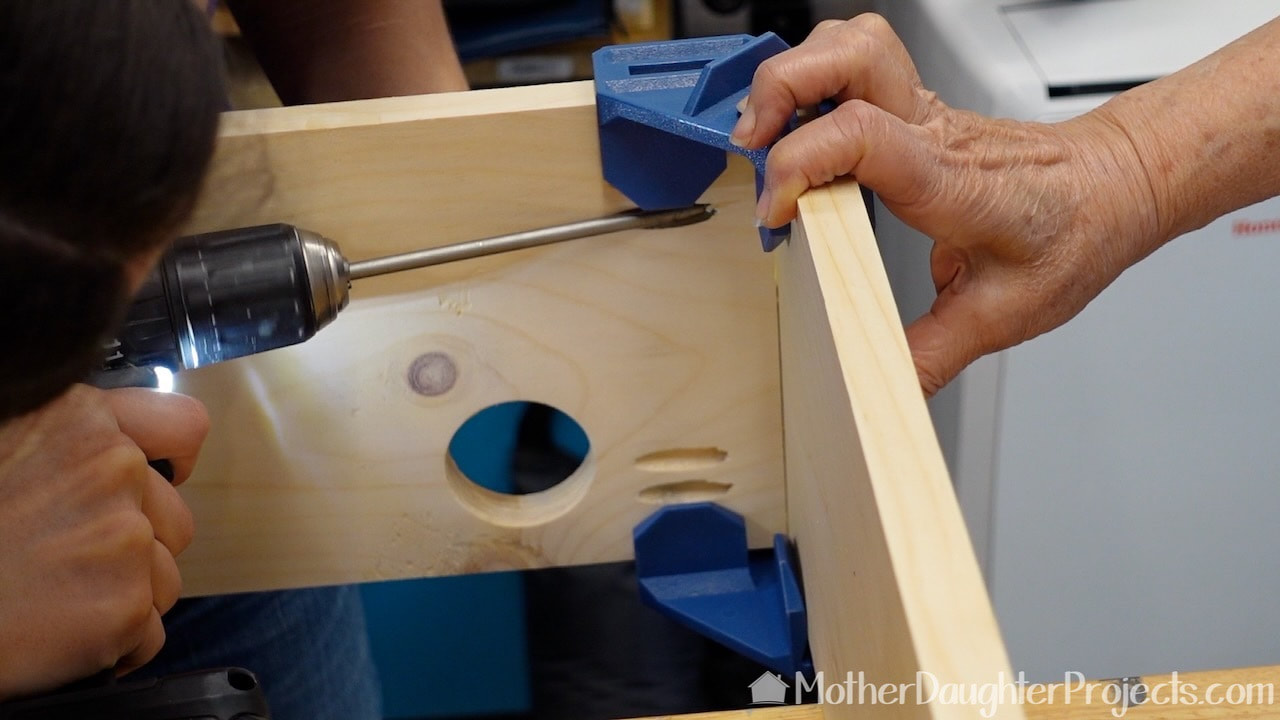 Those blue Rockler corner clamps keep the corners square and in place while screwing in the pocket hole screws.