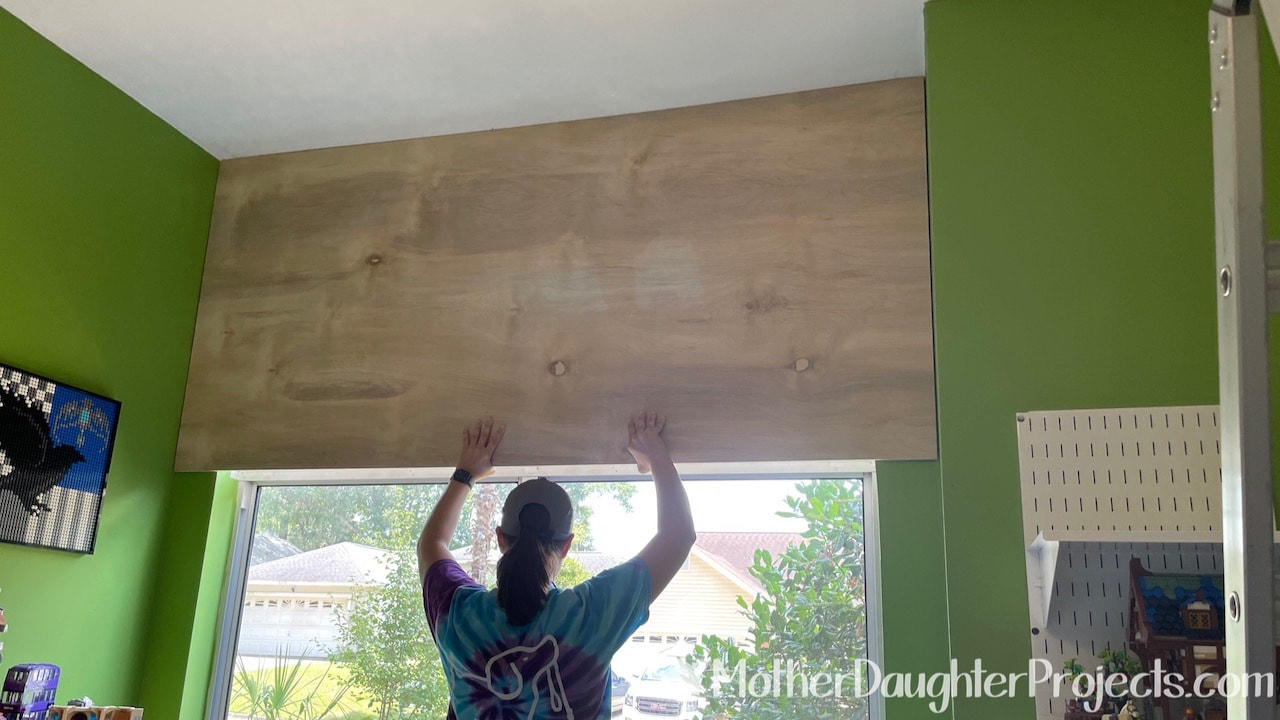 Covering the window with 1/2 plywood to support the shelf and block out the sun.