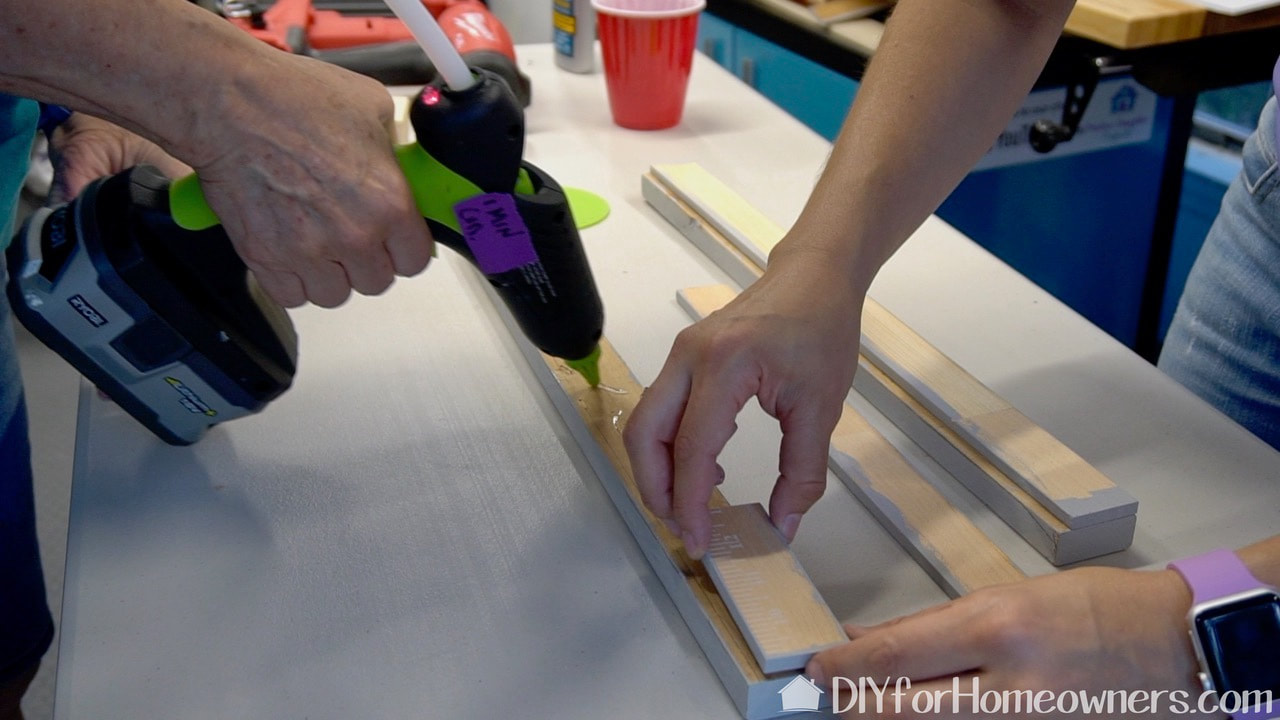Using a Surebonder hot glue gun to glue the frame pieces together. 