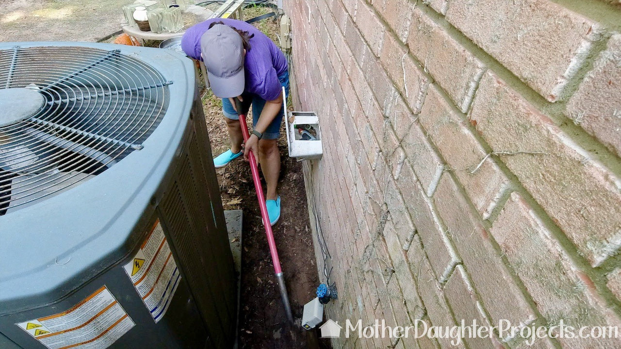 We cleared out on the back side of the fence as well to create an incline for the water to drain away from the wall.