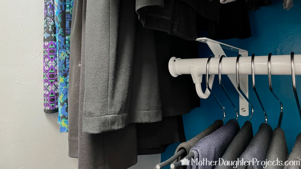 Creating space for longer clothes by cutting the original closet rod. 
