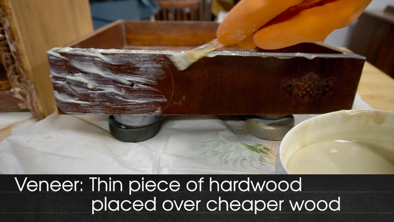 Using a paint remover on the veneer fronts of the desk drawers.