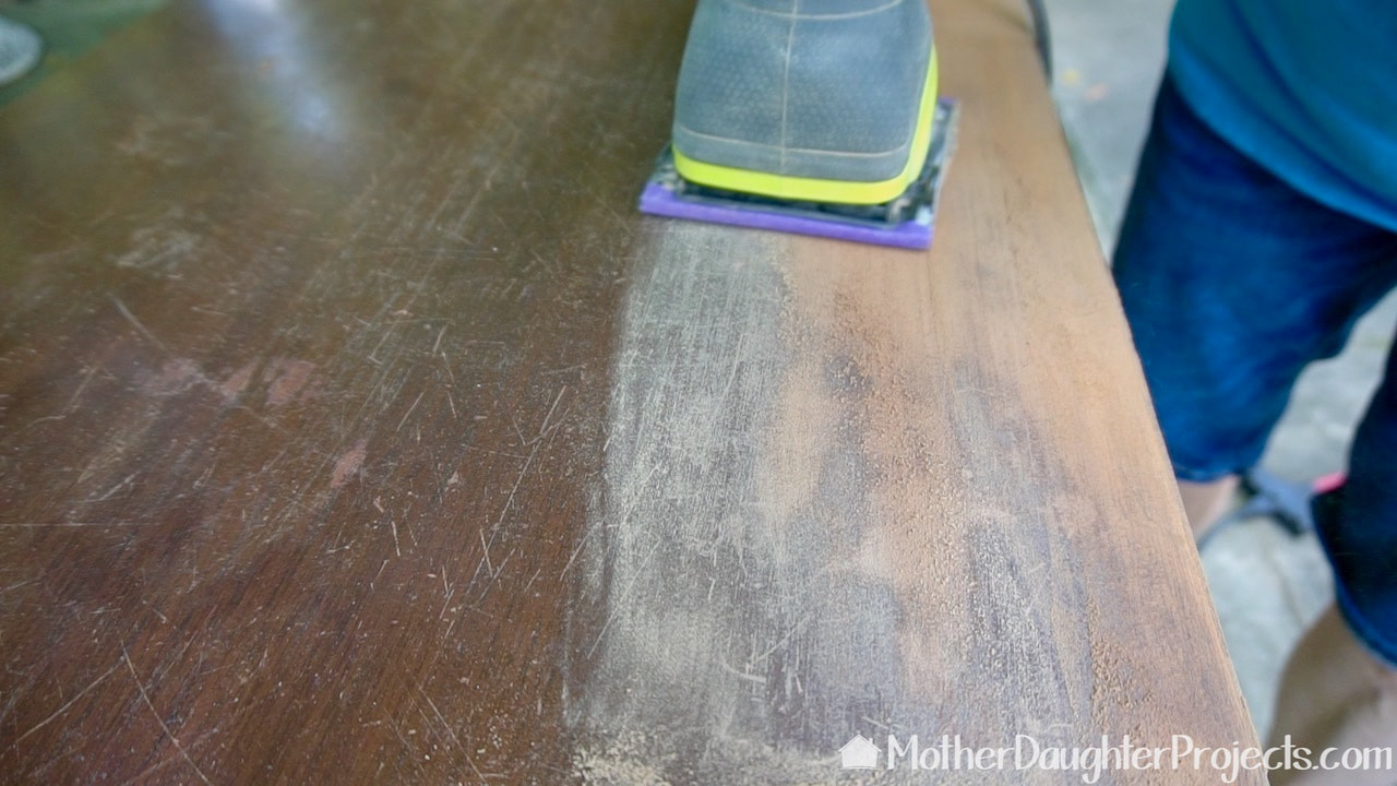 Using a corded Ryobi quarter sheet sander with 180 grit 3M sandpaper to remove the finish on the top.