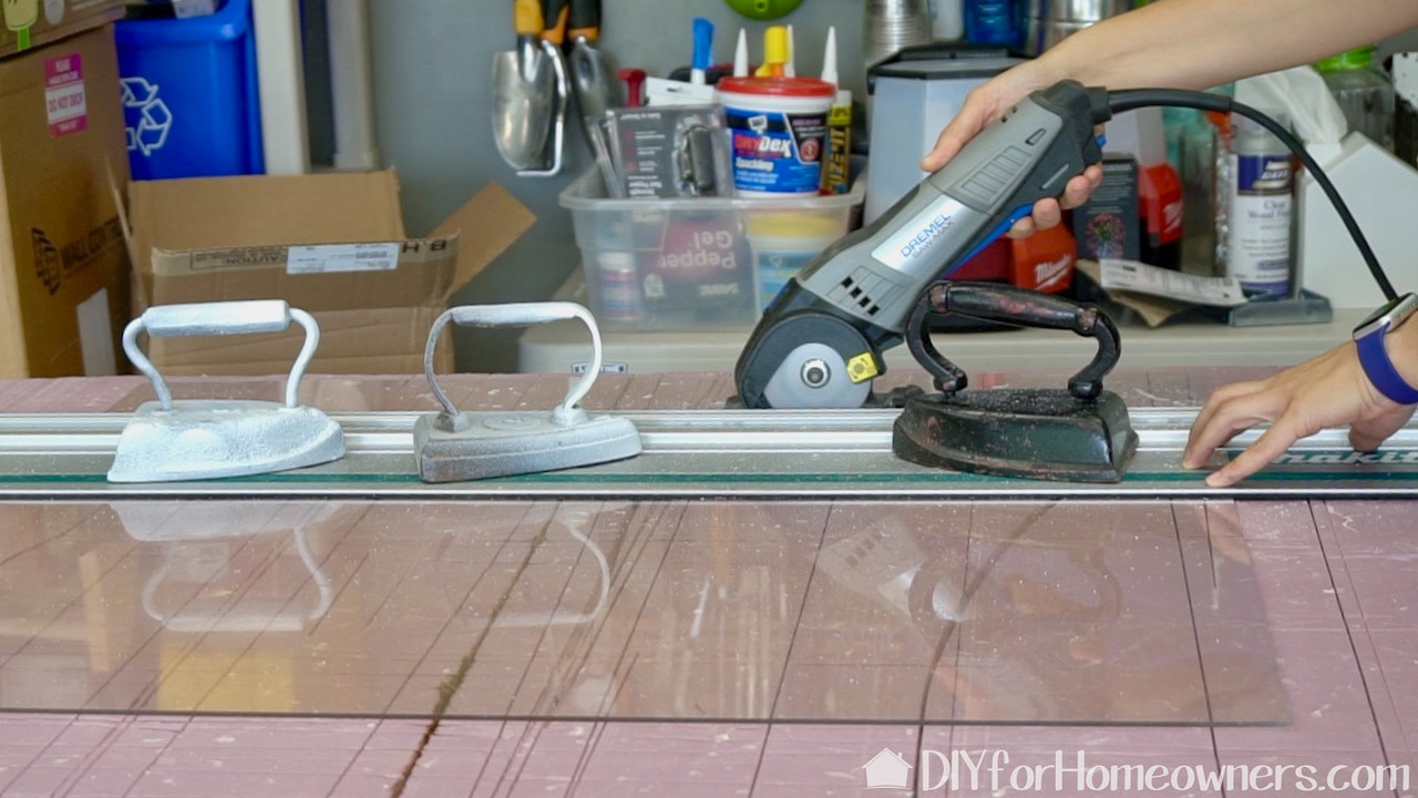 Steph is using a Dremel Saw-Max with a blade designed to cut plastic to easily and cleanly cut the plexiglass. 