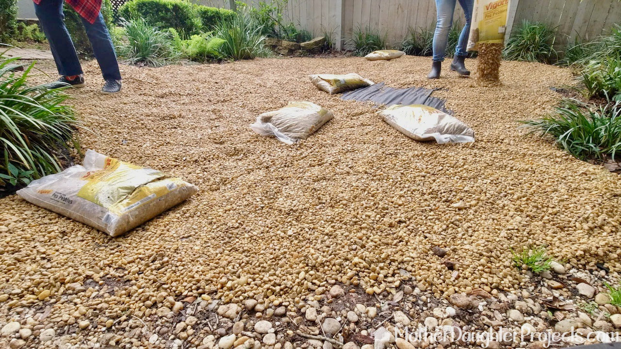 Adding the pea gravel pebbles to the backyard.