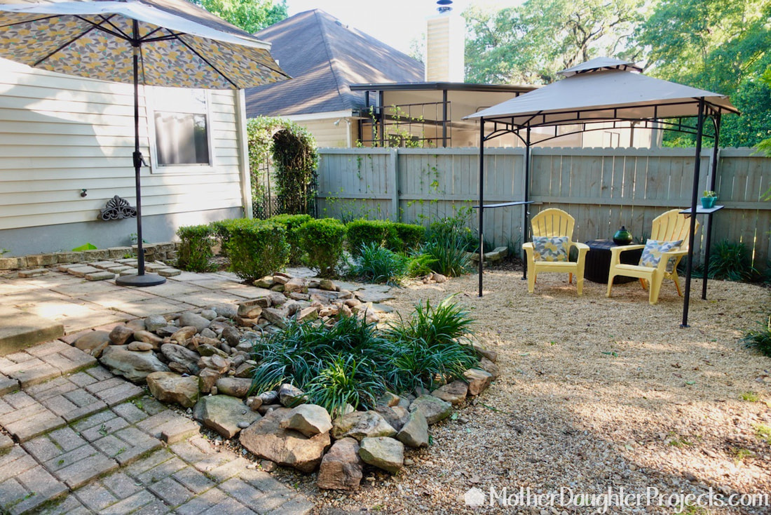 We added a small gazebo, pulled in a couple of chairs and storage box and arranged the former pond rocks to anchor the new backyard oasis space. 