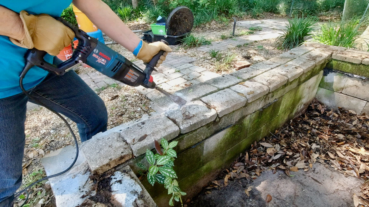 Using a Bosch rotary hammer with chisel tip to remove the concrete pavers.