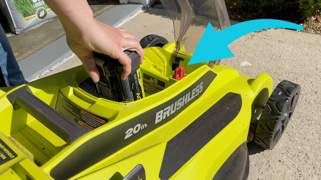 The enclosed Ryobi battery compartment on the walk behind push mower. 