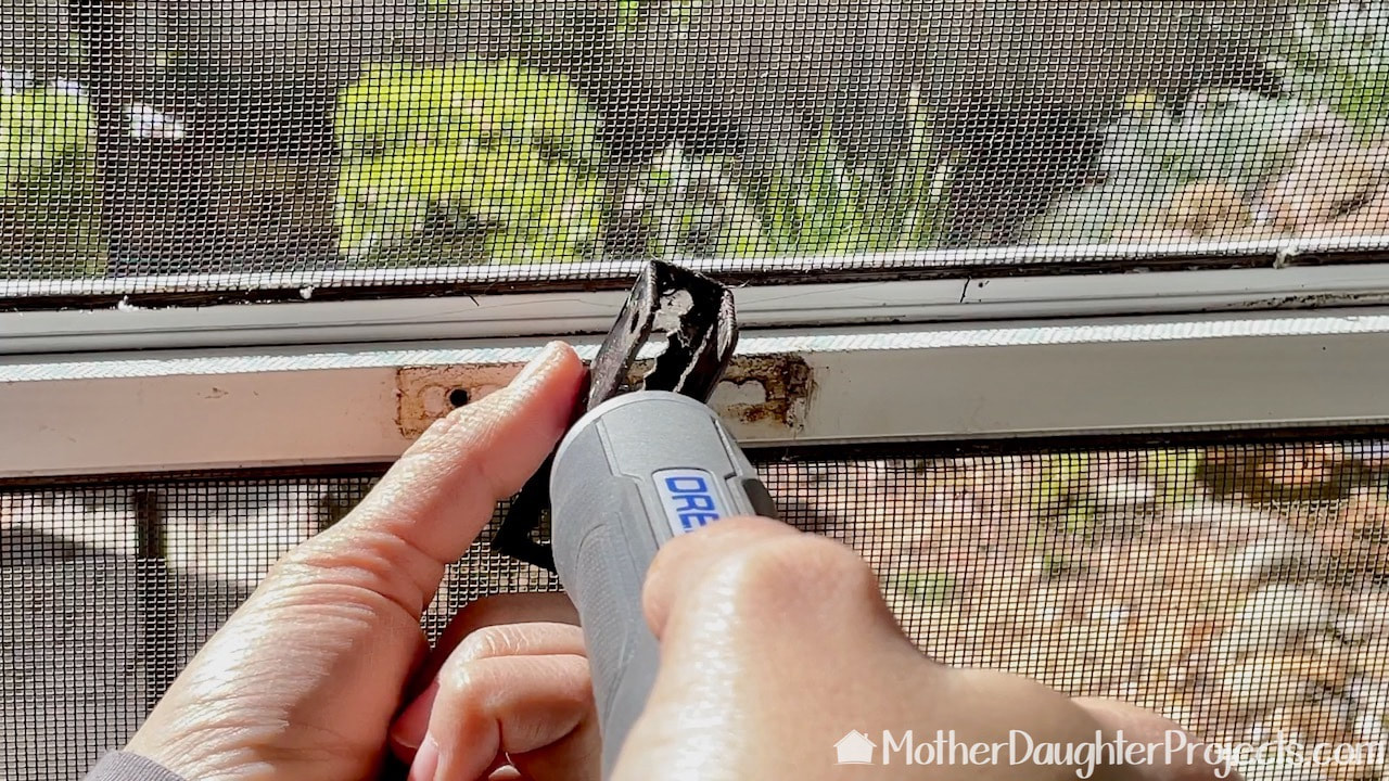 Using a Dremel power screwdriver to unscrew the door hardware. The Dremel is rechargeable.