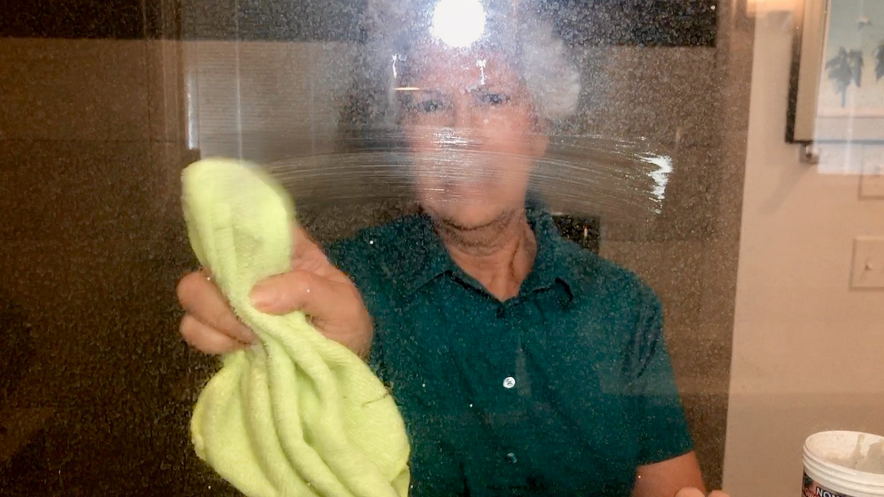Cleaning the shower glass with the Quick-Glo.