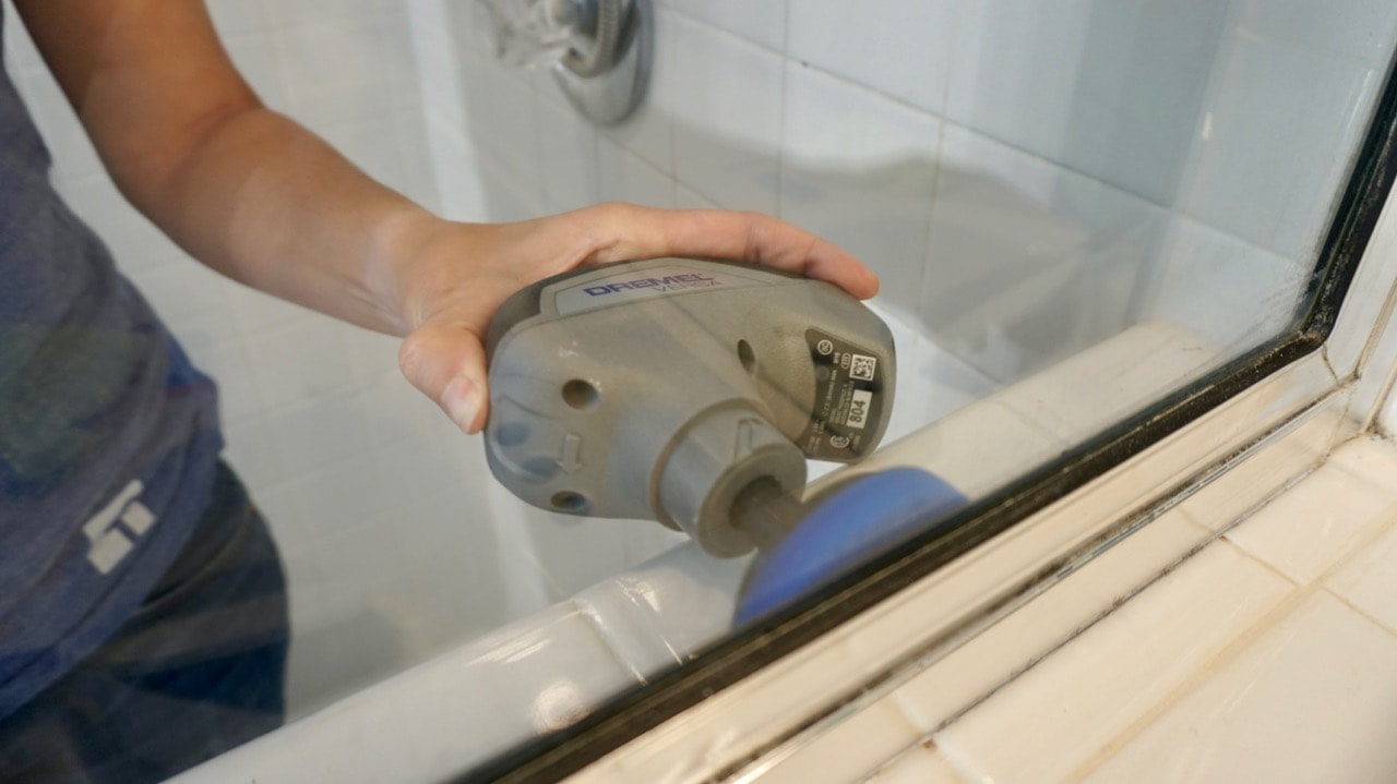 Using the Dremel Versa power scrubber on the inside of the shower. 