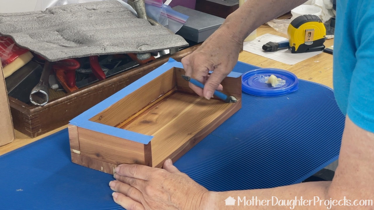 Applying wax to the interior of the table pocket.