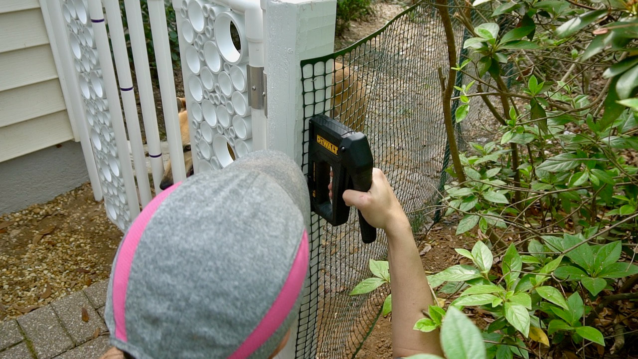 Using the DEWALT Carbon Fiber Tacker to secure the fencing to the gate post.