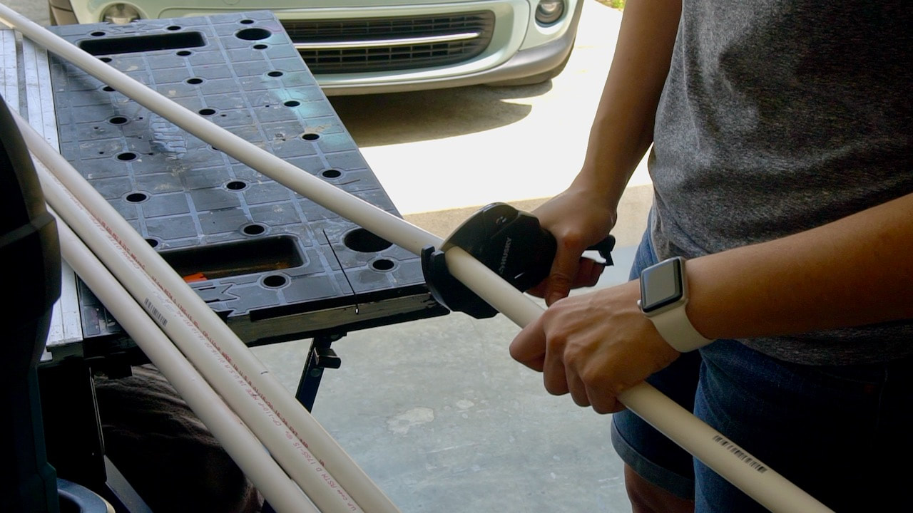 Using a Husky ratcheting PVC cutter to cut the one inch PVC pipe.