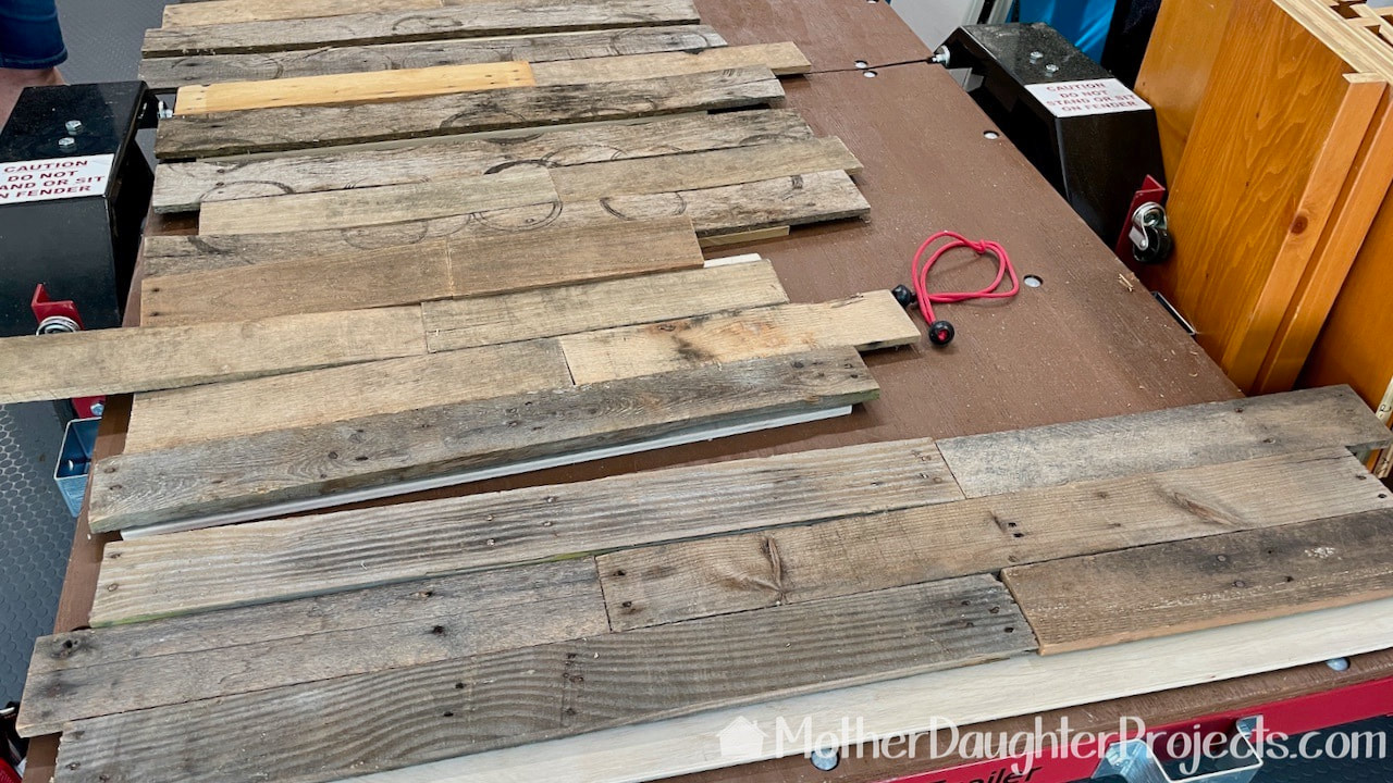 The pallet wood laid out on the sides of the under bed sliding storage boxes. 