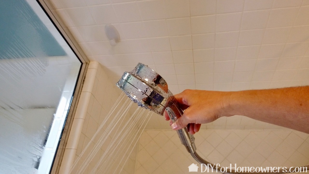 A hand held shower sprayer helps to completely wet down the shower walls.