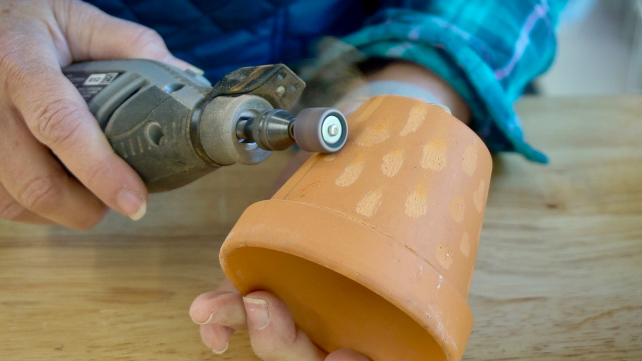 Dremel rotary tool with sanding attachment.