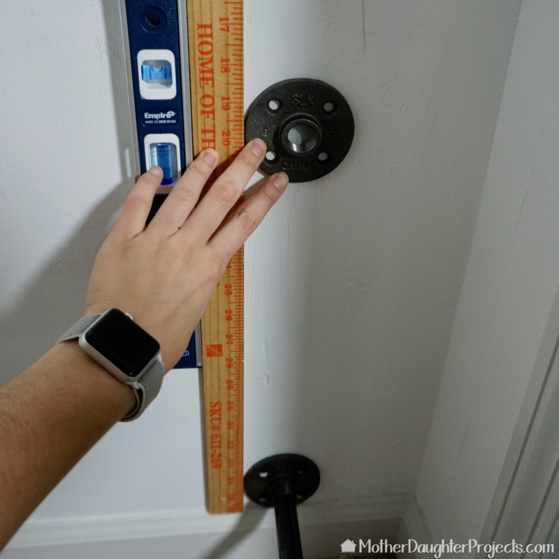 Use a level to line up the flanges on the wall.